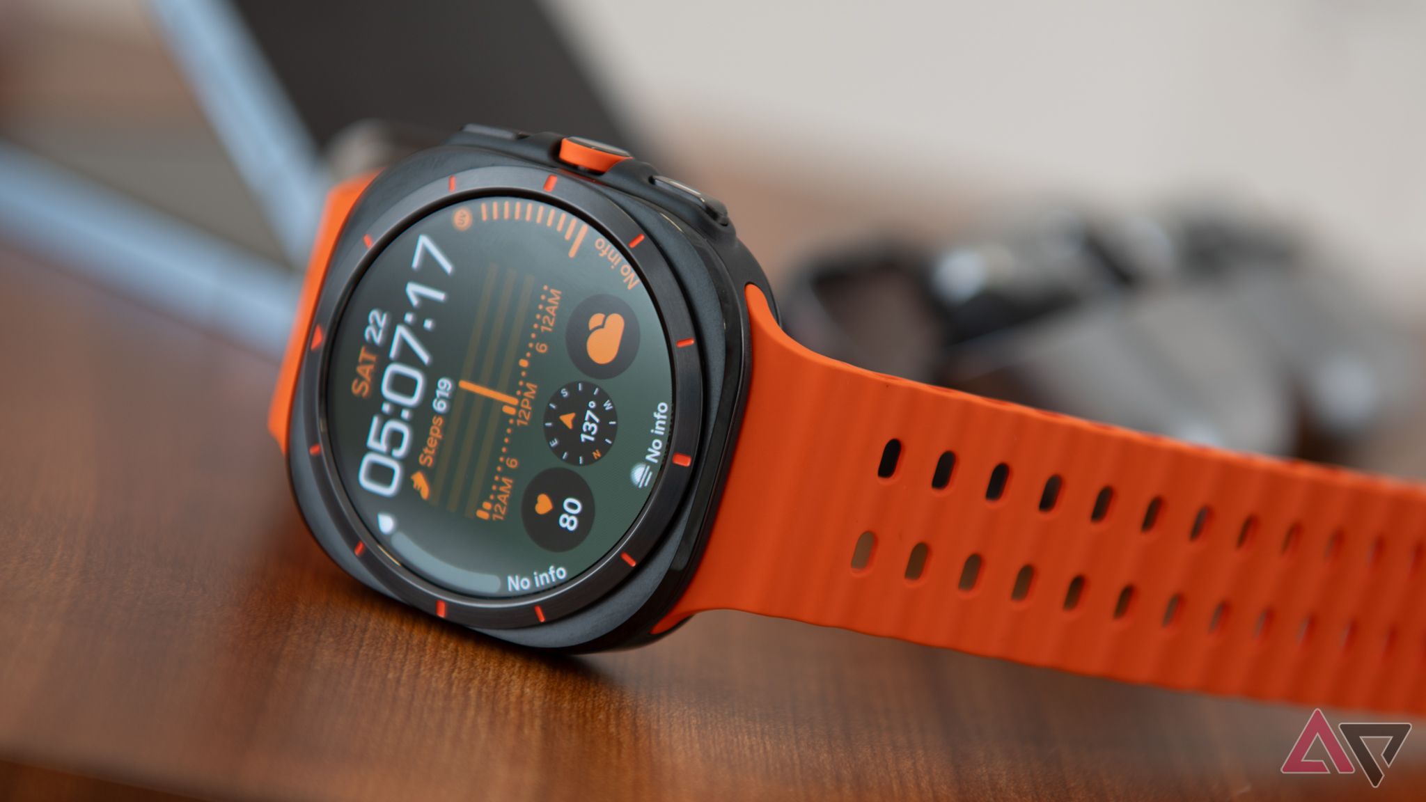 An orange Galaxy Watch Ultra sits on a table